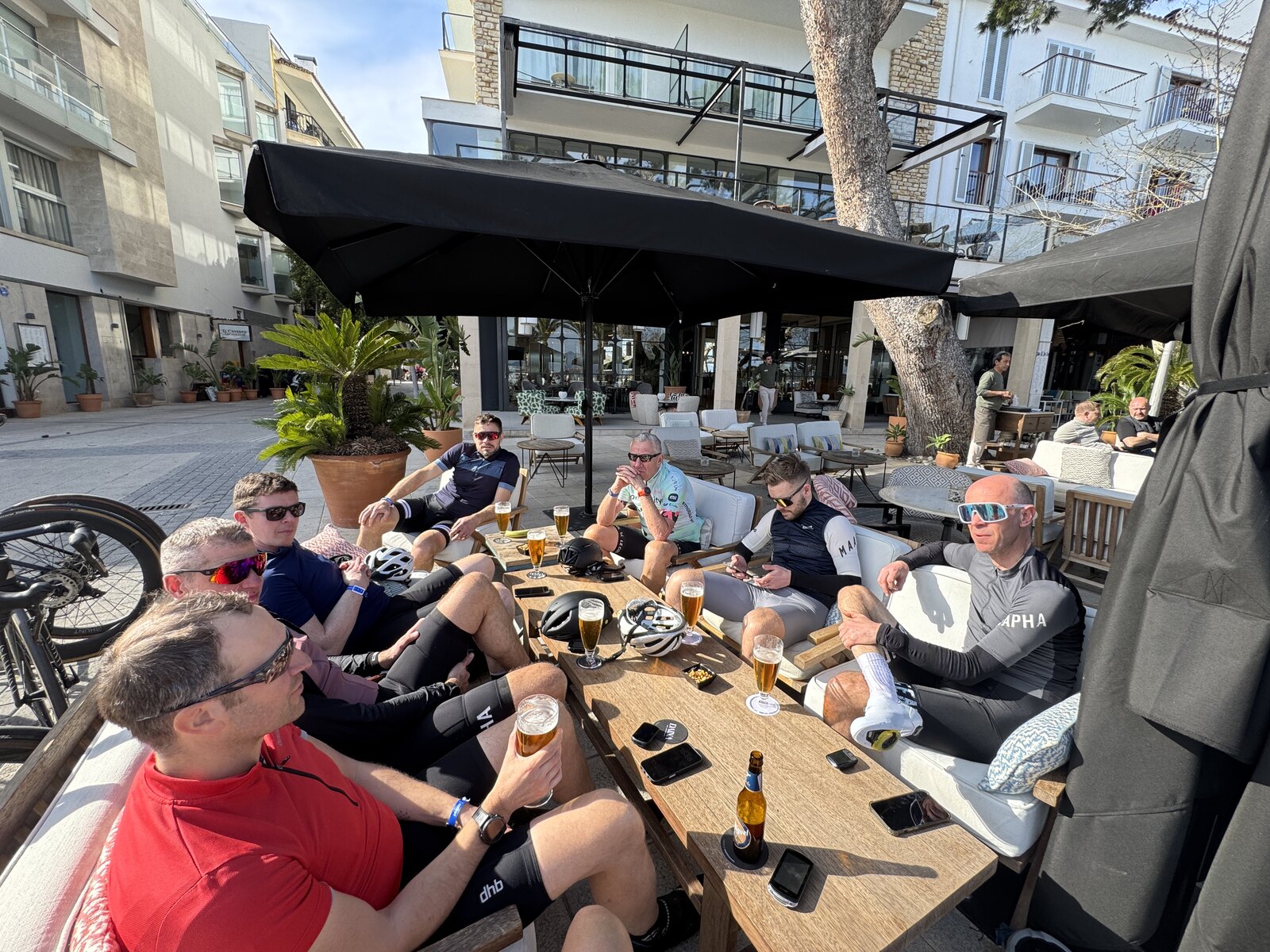 Cykelvenner nyder en pause sammen ved et bord i solen